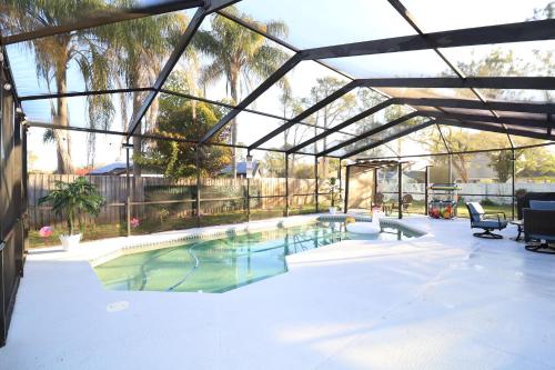 a large swimming pool with a canopy and chairs at Luxury Home Pool- Ideal paradise to play & work in Tampa