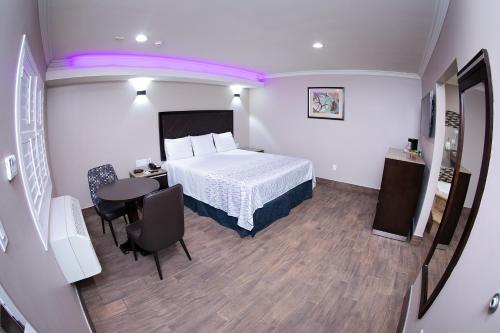 a hotel room with a bed and a table and chairs at Diamond Bell Inn & Suites in Bell