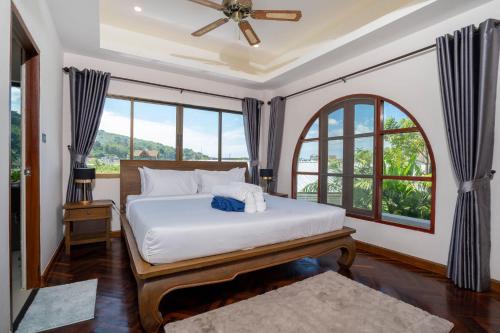 a bedroom with a bed and a window at Villa Amaya, 2 Story Tropical Oasis with Green Hills View & Pool, Kamala Beach in Kamala Beach