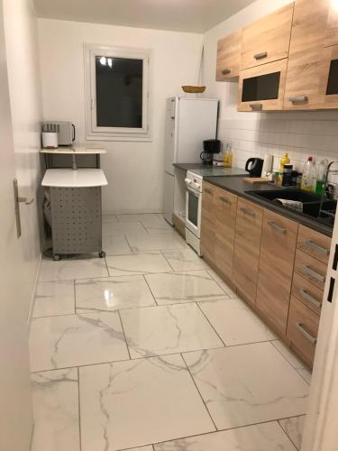 Il comprend une cuisine dotée d'un grand carrelage blanc. dans l'établissement L’amiral, à Rouen