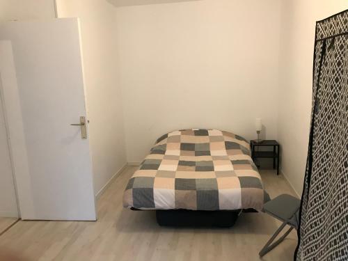 une petite chambre avec un lit et une chaise dans l'établissement L’amiral, à Rouen