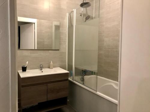 une salle de bain avec un lavabo et une douche dans l'établissement L’amiral, à Rouen