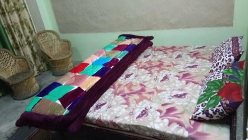 a bed with a colorful blanket on top of it at Roshyank Homestay in New Delhi