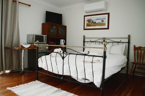 1 dormitorio con cama negra con sábanas blancas en Art Shack @ Wilgabah, en Wallabadah