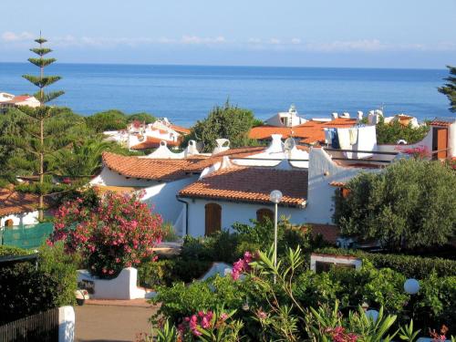 a group of houses with the ocean in the background at Sa Fiorida case vacanze in Valledoria