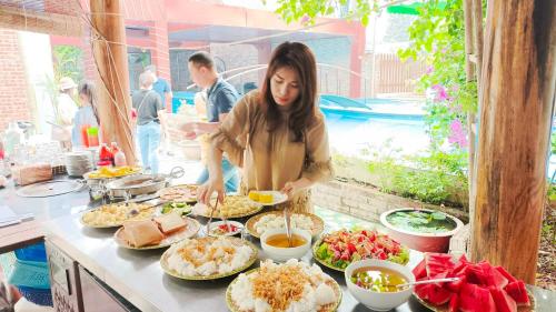 una mujer parada frente a un buffet de comida en Văn Lâm Villa en Ninh Binh