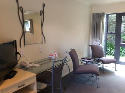 a room with a desk and chairs and a mirror at Chancellor Motor Lodge and Conference Centre in Palmerston North