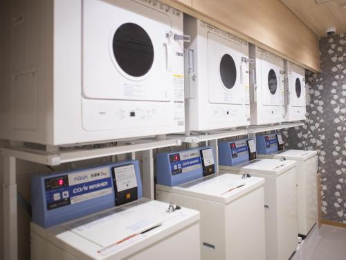 a row of washers and dryers in a room at Dormy Inn Premium Kyoto Ekimae Natural Hot Spring in Kyoto