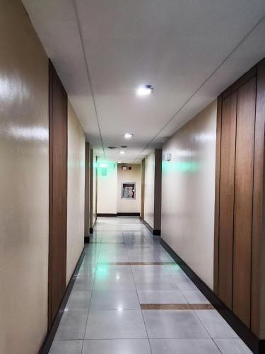 an empty hallway with wooden doors and a tile floor at The Besh Place - Baguio City in Baguio