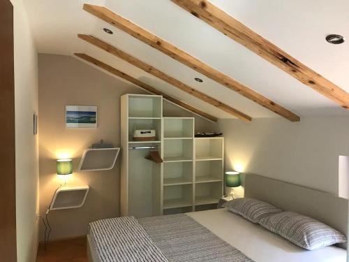 ein Schlafzimmer mit einem Bett in einem Zimmer mit Holzdecken in der Unterkunft Apartments Luki - great view in Smergo