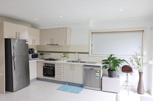 a kitchen with a stainless steel refrigerator and a sink at Melbourne Lovely Nest in Melbourne