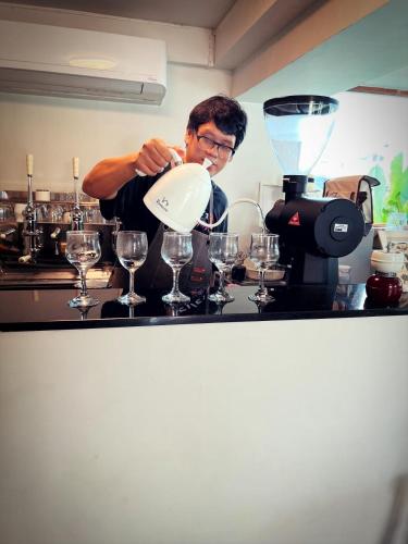 a man is pouring wine into a funnel at เฮือนริมน่าน Huen Rim Nan in Nan