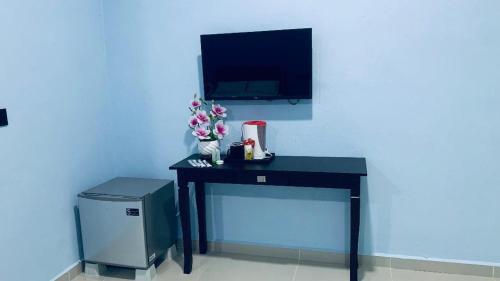 瓜埠的住宿－VILLA TASIK TONGKANG KELI LANGKAWI，一张黑色的桌子,墙上配有电视