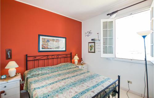 una camera da letto con pareti arancioni, un letto e una finestra di Awesome Apartment In Marina Di Ragusa With Kitchenette a Marina di Ragusa