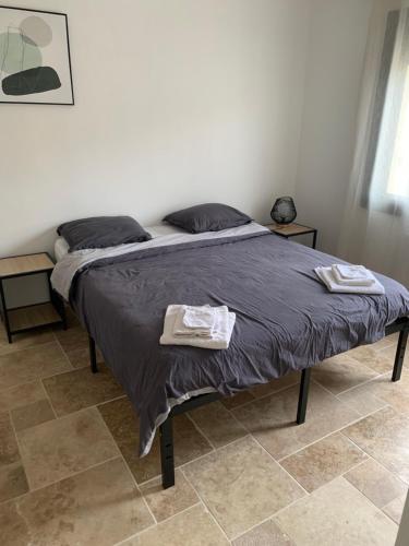Una cama en un dormitorio con dos toallas. en Villa 18, en Narbona