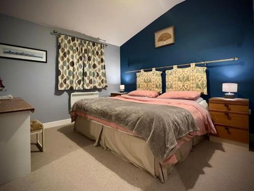 um quarto com uma cama com uma parede azul em Countryside in the Town. em Harlescott