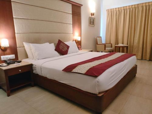 a hotel room with a large bed and a chair at Cochin Palace in Cochin