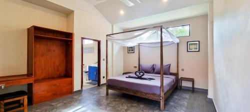 a bedroom with a canopy bed in a room at Villa Pacha in Kampot