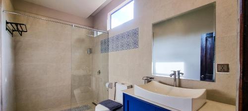 a bathroom with a sink and a shower with a mirror at Villa Pacha in Kampot