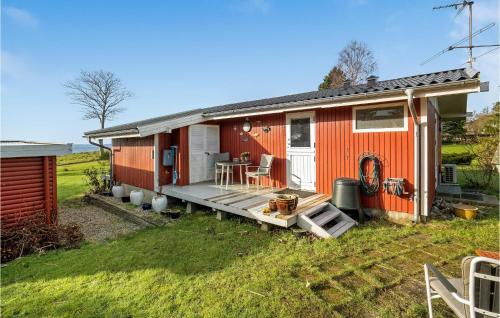 a red house with a deck in the yard at Amazing Home In Mesinge With Kitchen in Mesinge