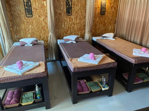 three beds in a room with towels on them at Little Mermaid Guesthouse & Restaurant in Kata Beach