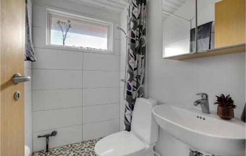 uma casa de banho com um lavatório, um WC e uma janela. em Amazing Home In Mesinge With Kitchen em Mesinge