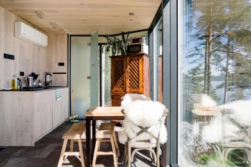 The WonderInn Mirrored Glass Cabin - Wonderinn Delta في Hektner: مطبخ مع طاولة وكراسي ونافذة
