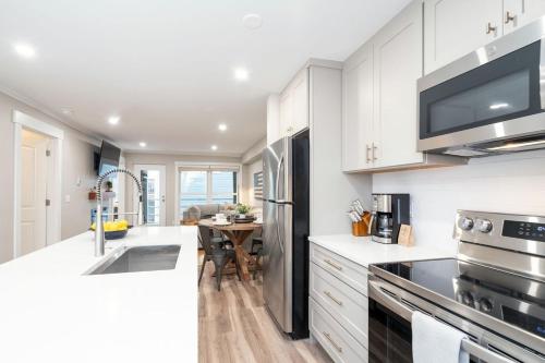 una cucina con armadi bianchi e un tavolo di Perfect Location! King Bed, Full Kitchen, Walk to Gondola condo a Telluride