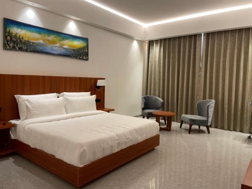 um quarto com uma cama, 2 cadeiras e uma mesa em The Mars Resorts em Meerut