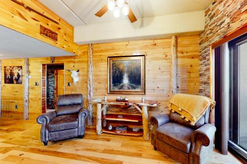 two chairs and a table in a room with wooden walls at Cabin Retreat at Sugar Top in Sugar Mountain