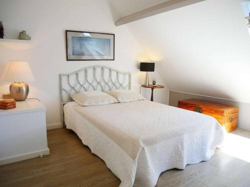 1 dormitorio con cama blanca y colcha blanca en Appartement La Trinité-sur-Mer, 3 pièces, 4 personnes - FR-1-477-157, en La Trinité-sur-Mer