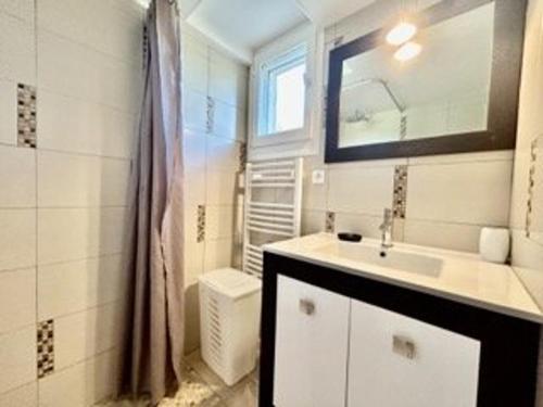 une salle de bain blanche avec un lavabo et un miroir dans l'établissement Appartement proche plage, climatisé, 5 pers – Sainte-Maxime - FR-1-226-427, à Sainte-Maxime