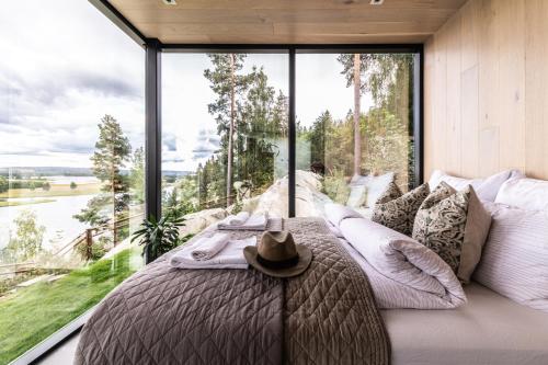 a bedroom with a bed with a large window at The WonderInn Mirrored Glass Cabin - Wonderinn Delta in Hektner