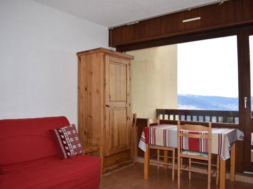 un salon avec un canapé rouge et une table dans l'établissement Studio cabine pour 4 personnes avec parking à Font-Romeu - FR-1-580-38, à Font-Romeu-Odeillo-Via