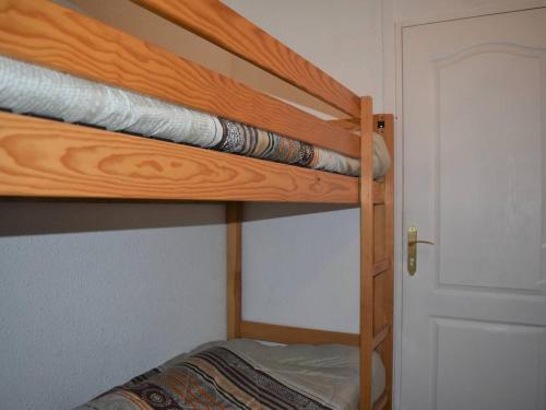 Ce lit superposé se trouve dans un dortoir doté de lits superposés en bois. dans l'établissement Studio cabine pour 4 personnes avec parking à Font-Romeu - FR-1-580-38, à Font-Romeu-Odeillo-Via