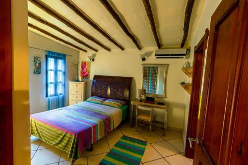 a bedroom with a bed and a desk in it at Villa Cococaribic Isla Margarita Venezuela in Paraguchi