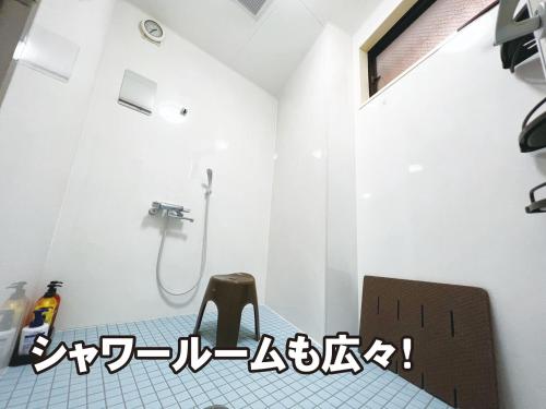 a bathroom with a chair and a shower at 琉球カプセルホテル8131那覇国際通り in Naha