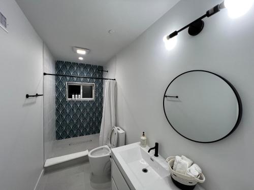 W łazience znajduje się umywalka, lustro i prysznic. w obiekcie New Luxury Home with DTLA Views - Ideal for Groups w Los Angeles