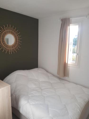 une chambre avec un lit avec un miroir et une fenêtre dans l'établissement Appartement T2 avec vue - Port Leucate - 4 personnes, à Leucate
