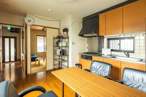 a kitchen with a wooden table and a dining room at アンドステイ西新井 in Tokyo