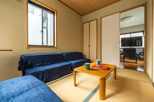 a living room with a blue couch and a table at アンドステイ西新井 in Tokyo