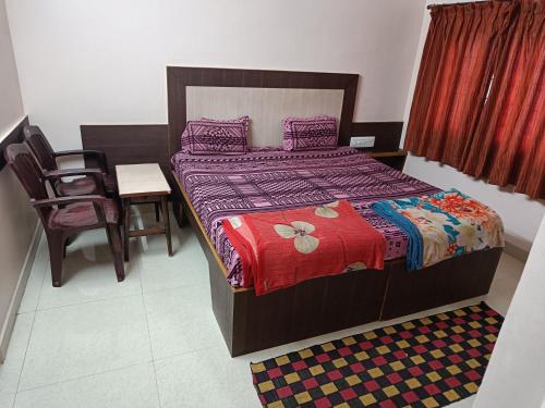 um quarto com uma cama, uma mesa e uma cadeira em Sri vishnu krupa lodging em Belūr