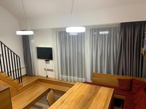 a living room with a wooden table and a television at Palava eu 9 in Pavlov