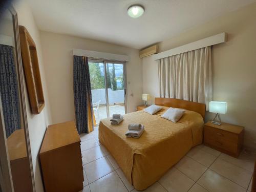 a bedroom with a bed and a window at Pissouri Beach Apartments in Pissouri