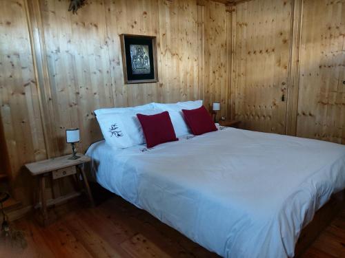 - une chambre avec un grand lit blanc et des murs en bois dans l'établissement Ca' Myosotis, à Cortina dʼAmpezzo