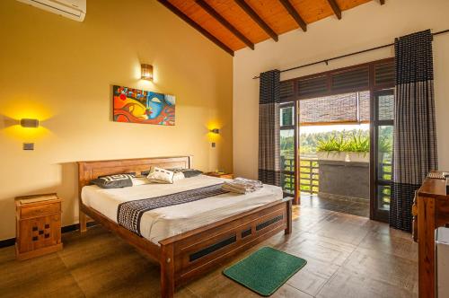 a bedroom with a bed and a large window at Yamu Lanka Inn in Malabe