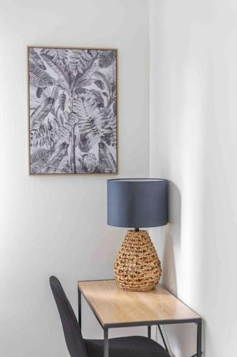 a lamp sitting on a table next to a chair at Le cosy : proche cdg-parc des expo-Paris-Disney in Sevran