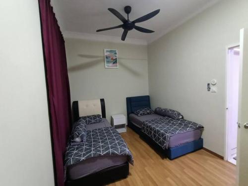 sypialnia z 2 łóżkami i wentylatorem sufitowym w obiekcie HS Homestay w mieście Sandakan