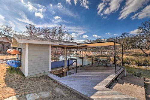 a house with a wooden deck next to a river at Lake LBJ Waterfront Vacation Rental! in Granite Shoals