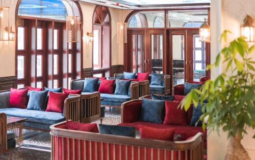 a lobby with blue and red couches and windows at Grand Fleuve Boutique in Ha Long